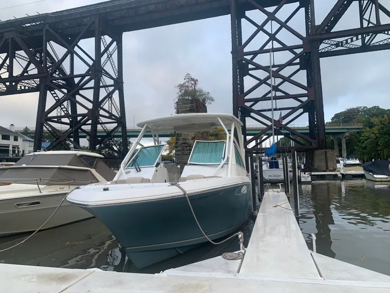 Slide: The Image of 2017 Sailfish 245 DC boat docked under bridge. - 6