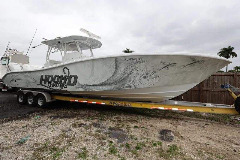 Slide: The Image of 2017 Yellowfin 36 Offshore boat on trailer with custom fish graphics and "Hooked Charters" logo. - 0