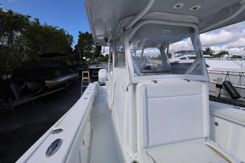 Slide: The Image of 2017 Yellowfin 36 Offshore boat with sleek white design, docked near other vessels. - 17