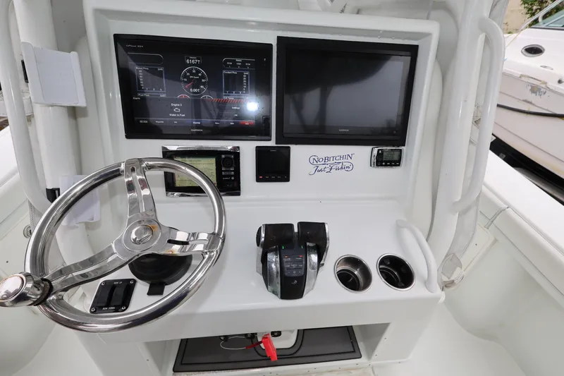 Slide: The Image of 2017 Yellowfin 36 Offshore boat dashboard with steering wheel and navigation screens. - 22