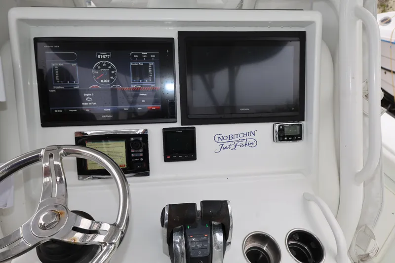 Slide: The Image of 2017 Yellowfin 36 Offshore boat dashboard with Garmin displays and steering wheel. - 23