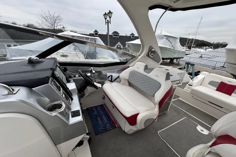 Slide: The Image of 2012 Chaparral 327 SSX boat interior with modern dashboard and plush seating at a marina. - 15