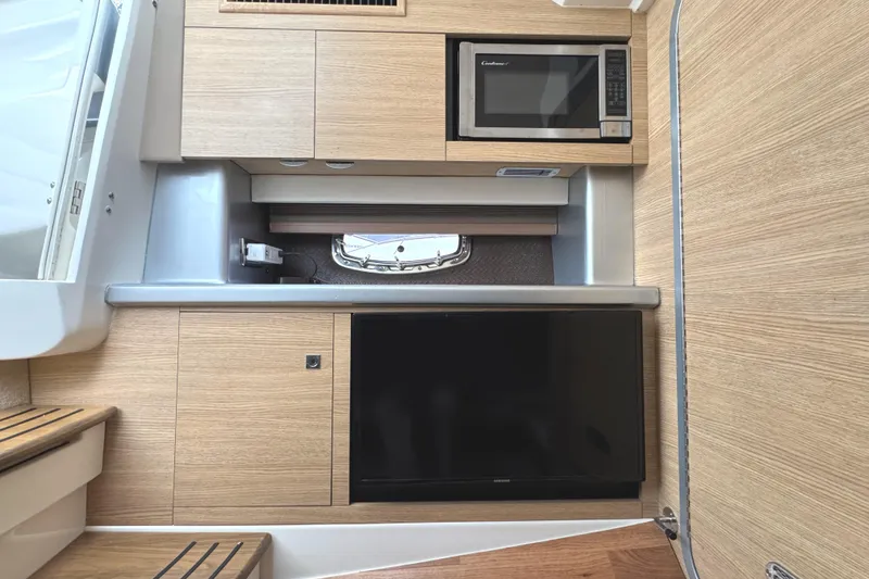 Slide: The Image of 2012 Chaparral 327 SSX interior with microwave and TV in modern wood finish. - 20