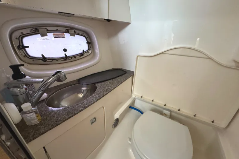 Slide: The Image of 2012 Chaparral 327 SSX boat bathroom with sink, toilet, and porthole window. - 24