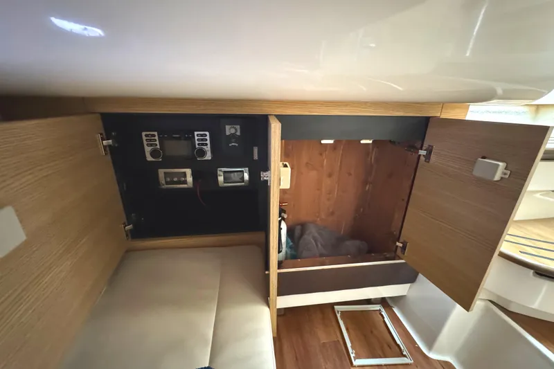 Slide: The Image of 2012 Chaparral 327 SSX interior storage with open wooden cabinets and control panel. - 26