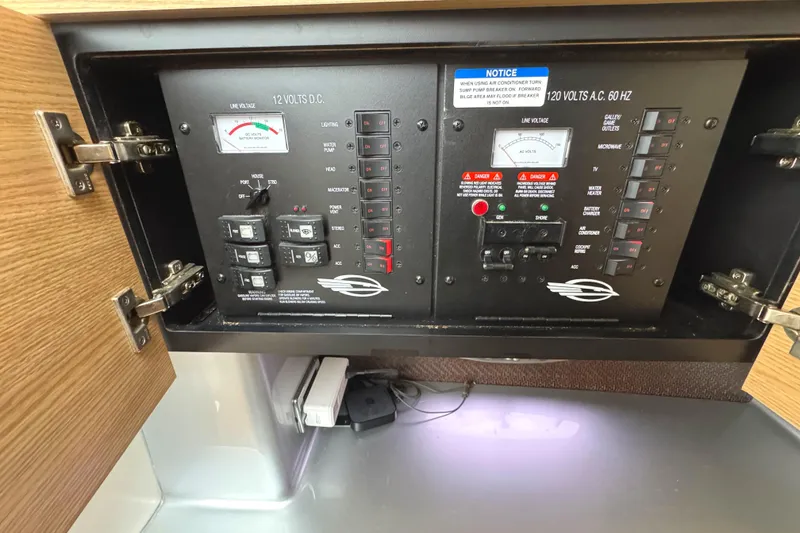 Slide: The Image of Electrical control panel inside 2012 Chaparral 327 SSX boat, featuring switches and meters. - 27