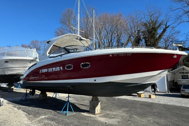 Slide: The Image of 2012 Chaparral 327 SSX boat in dry dock, red hull, clear sky background. - 6