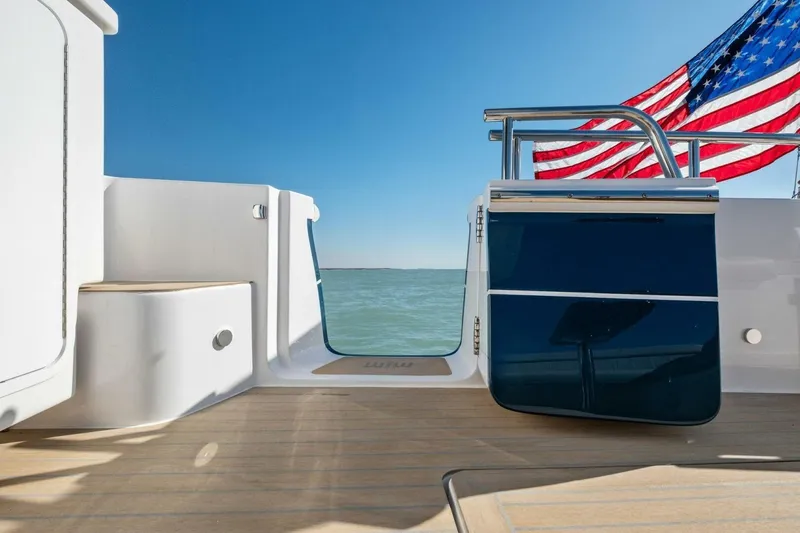 Slide: The Image of 2026 MJM 47R yacht deck with American flag, overlooking serene ocean view. - 28