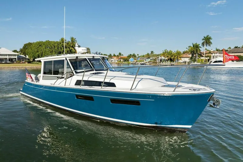 Slide: The Image of 2026 MJM 47R yacht cruising on a sunny day in a scenic waterfront setting. - 39