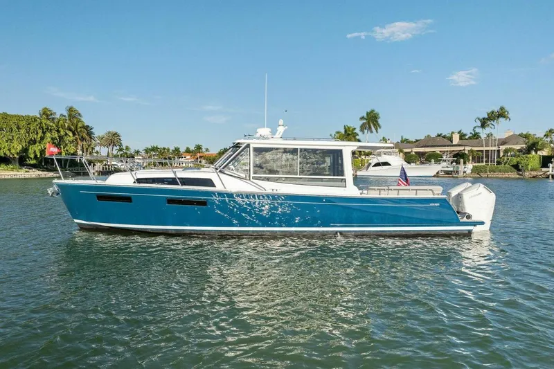 Slide: The Image of 2026 MJM 47R yacht on calm water, blue hull, sunny day, palm trees in background. - 43