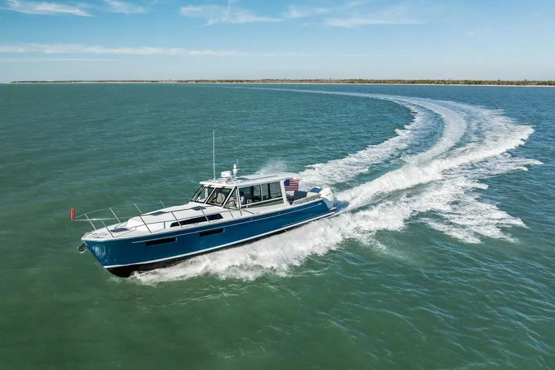 Slide: The Image of 2026 MJM 47R yacht cruising on open water under clear skies. - 49