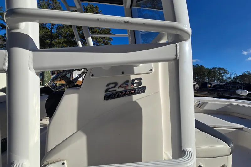 Slide: The Image of 2022 Robalo 246 Cayman SD boat detail with logo and railing in sunlight. - 3