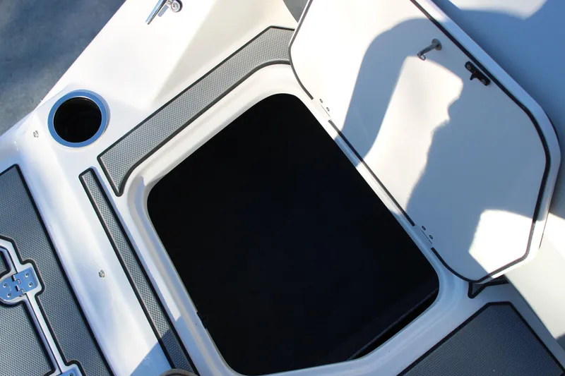 Slide: The Image of Open storage compartment on 2026 Starcraft SV 18 OB boat, featuring cup holder and textured surface. - 9