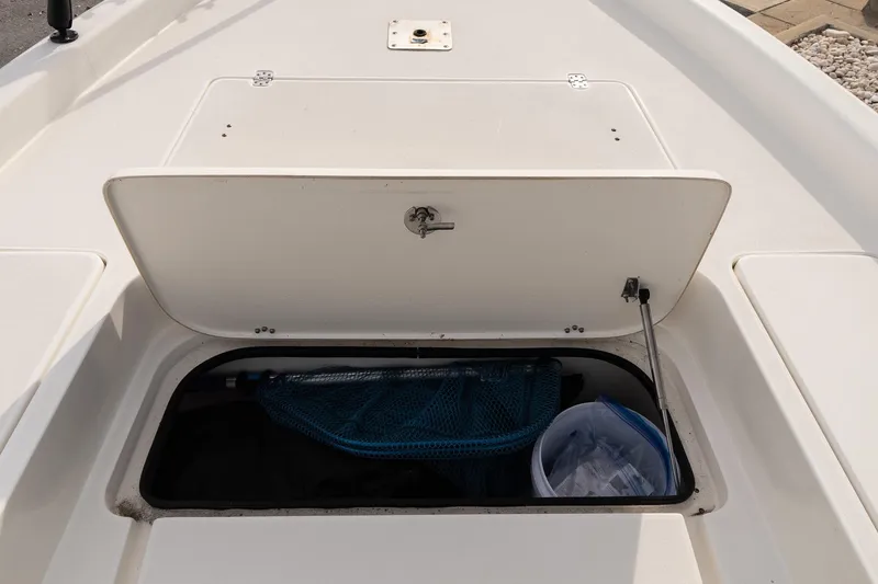 Slide: The Image of Open storage compartment on 2021 ShearWater 25LTD boat, containing fishing gear. - 18