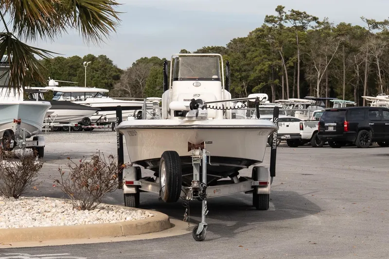 Slide: The Image of ShearWater 25LTD 2021 boat on trailer in parking lot with trees and vehicles. - 3