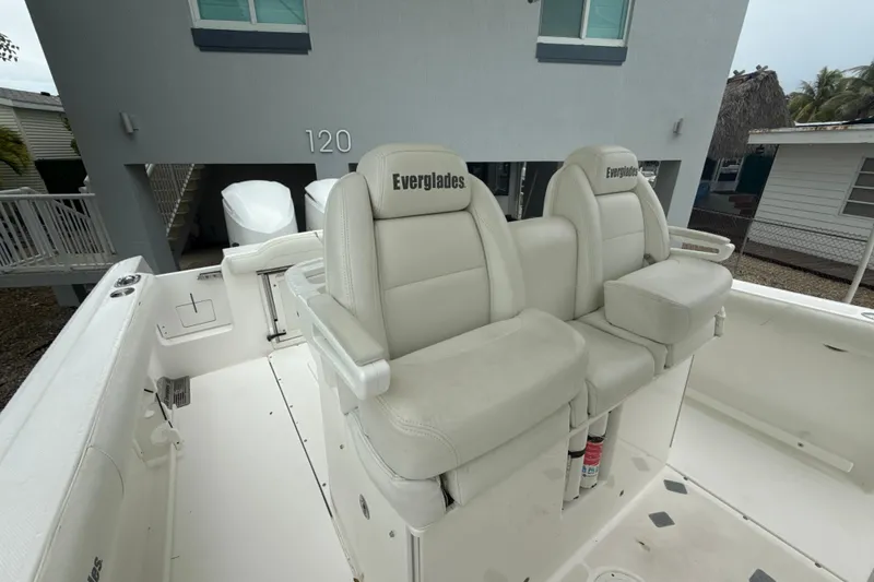 Slide: The Image of 2016 Everglades 295 Center Console boat with dual white seats and branded upholstery. - 24