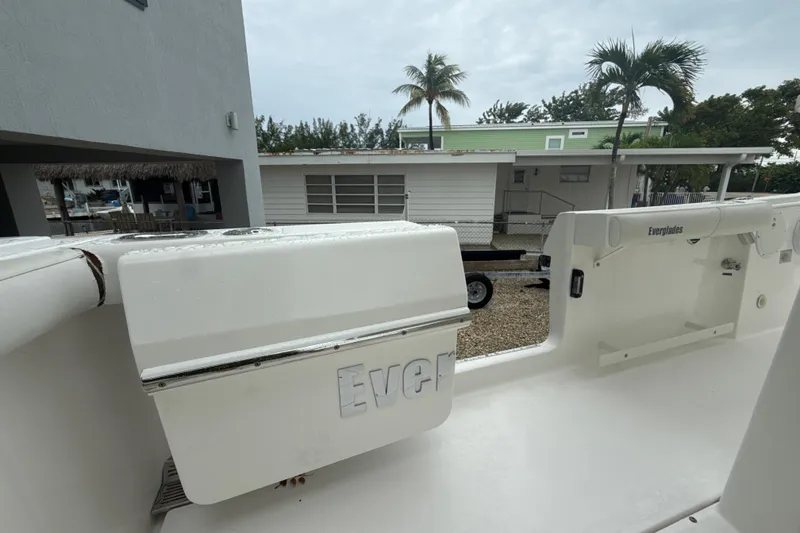Slide: The Image of 2016 Everglades 295 Center Console boat interior with palm trees and house in background. - 26