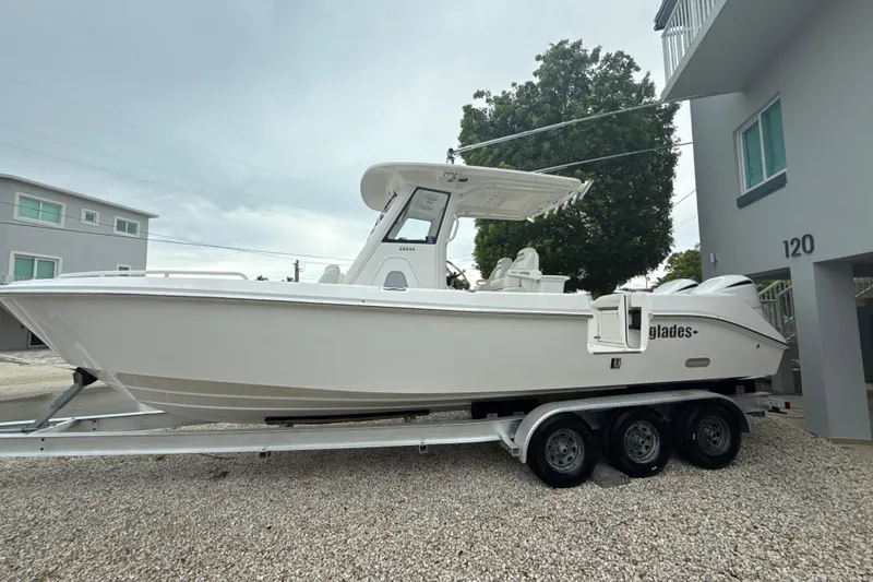 Slide: The Image of 2016 Everglades 295 Center Console boat on trailer, parked outdoors. - 3
