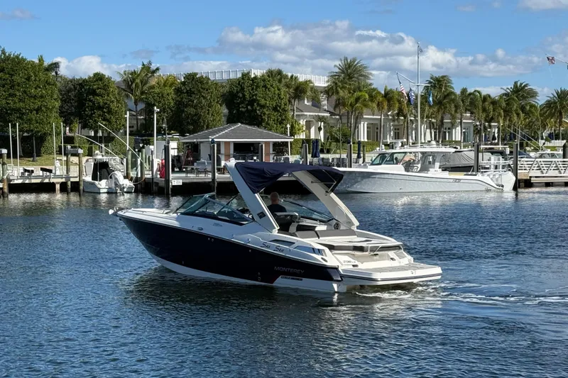 Slide: The Image of 2017 Monterey 298SS Super Sport boat cruising near a marina with palm trees. - 15