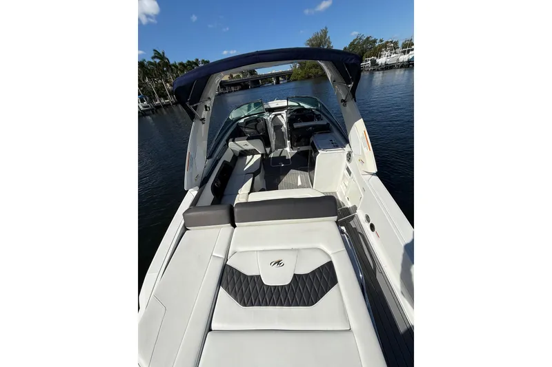 Slide: The Image of 2017 Monterey 298SS Super Sport boat interior with seating and helm, docked on calm water. - 23