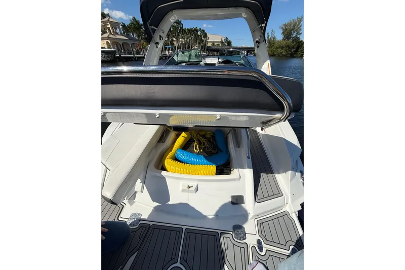 Slide: The Image of 2017 Monterey 298SS Super Sport boat with open storage compartment, docked by waterfront homes. - 24