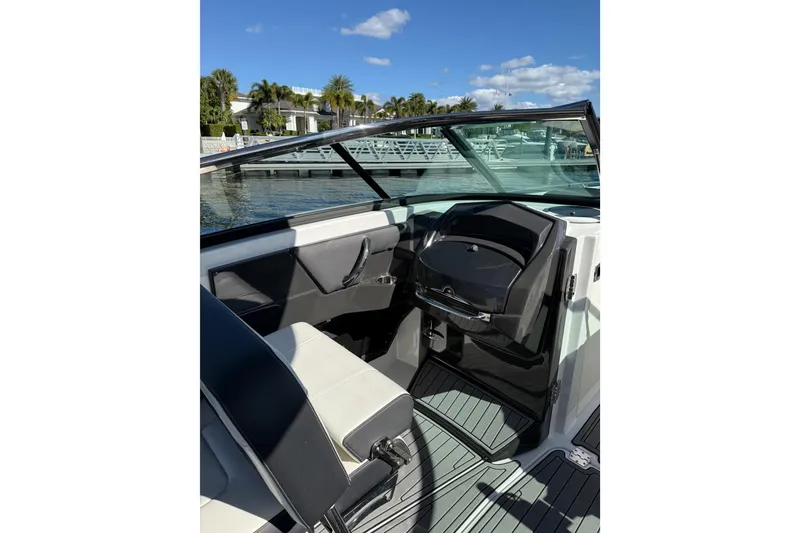 Slide: The Image of 2017 Monterey 298SS Super Sport boat interior with sleek seating and dashboard, dockside view. - 26