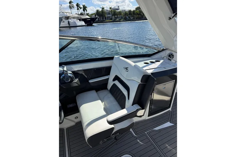 Slide: The Image of Captain's seat on 2017 Monterey 298SS Super Sport boat, overlooking serene waterfront. - 29