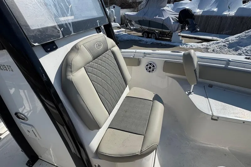Slide: The Image of 2026 Key West 219 FS boat interior with cushioned seating and snowy background. - 12