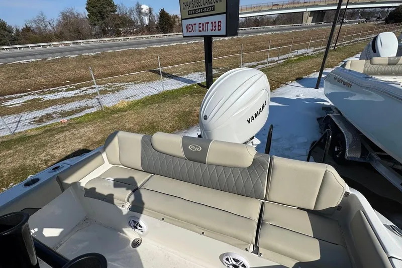 Slide: The Image of 2026 Key West 219 FS boat with Yamaha engine, parked near highway exit. - 17
