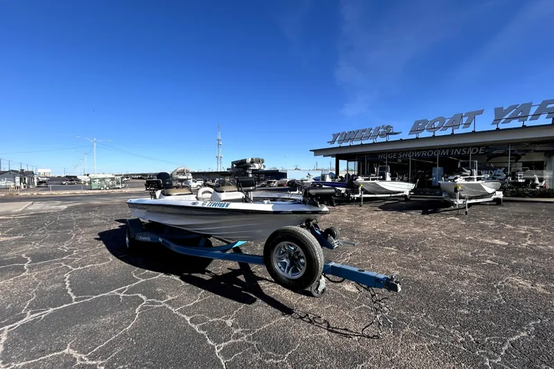 Slide: The Image of 2003 Champion 187 CX boat on trailer at a boat yard under clear blue sky. - 1