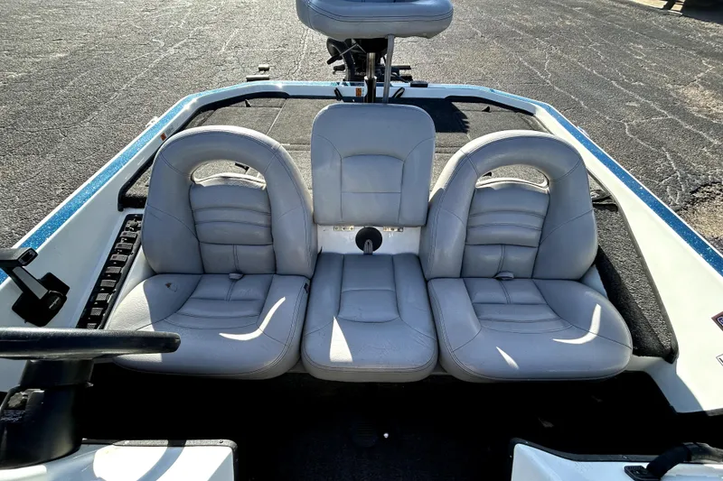 Slide: The Image of 2003 Champion 187 CX boat interior with three gray seats and steering wheel. - 17