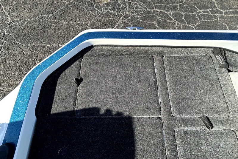 Slide: The Image of 2003 Champion 187 CX boat deck with textured carpet and blue trim. - 27