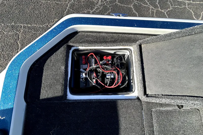 Slide: The Image of Battery compartment of a 2003 Champion 187 CX boat with visible wiring. - 28