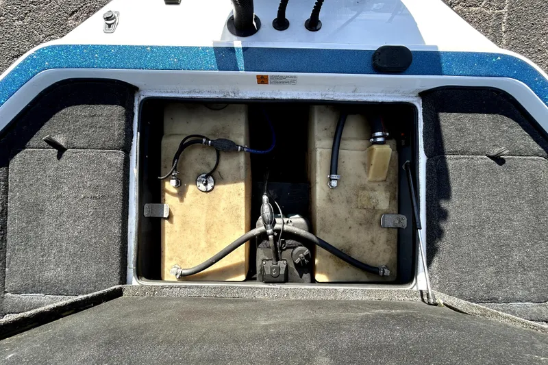 Slide: The Image of Open storage compartment of a 2003 Champion 187 CX boat, showing internal components. - 30