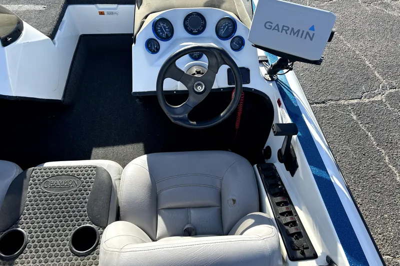 Slide: The Image of 2003 Champion 187 CX boat cockpit with Garmin GPS, steering wheel, and dashboard controls. - 32