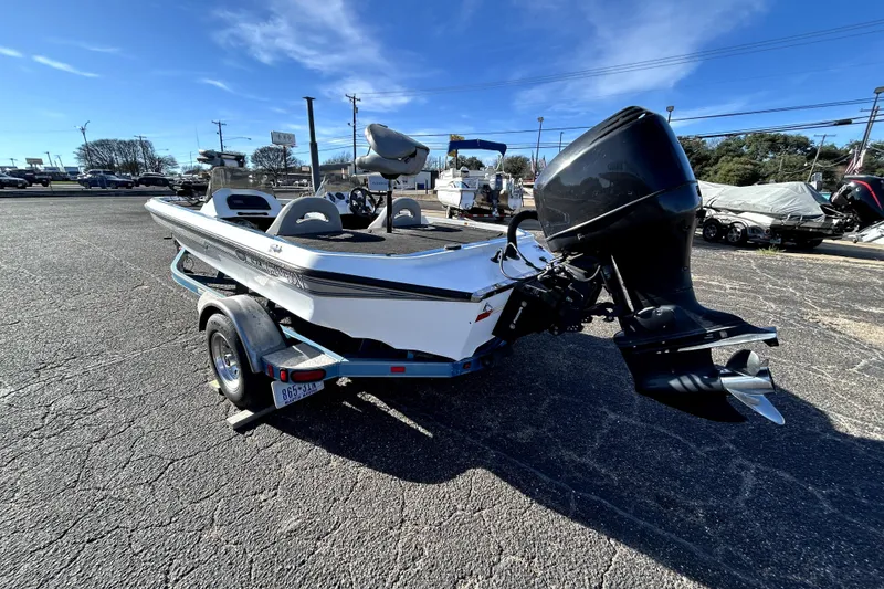 Slide: The Image of 2003 Champion 187 CX boat on trailer, parked outdoors under clear blue sky. - 4