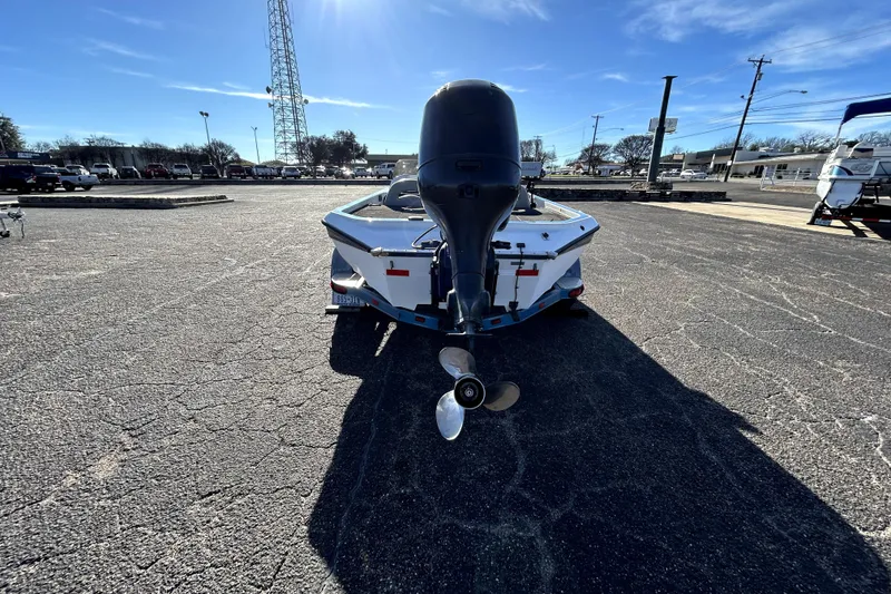 Slide: The Image of 2003 Champion 187 CX boat with outboard motor in a parking lot. - 5
