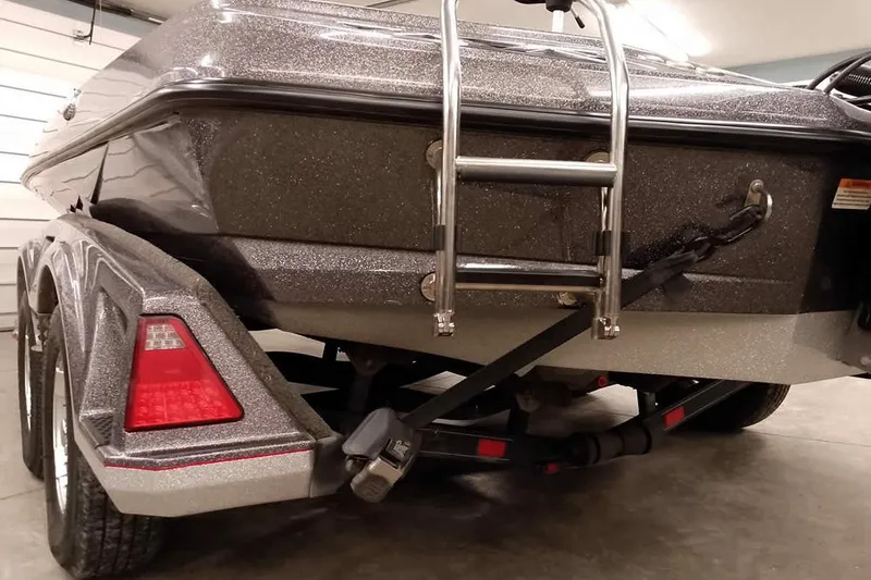Slide: The Image of 2021 Ranger Z520L boat rear view with ladder and trailer in garage. - 34