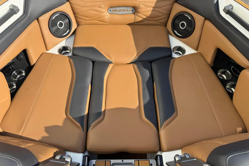 Slide: The Image of 2026 Supra SV 575 interior with tan and black leather seats, premium speakers, and cup holders. - 4