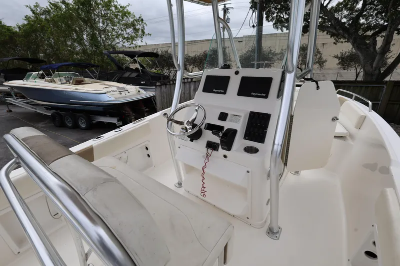 Slide: The Image of 2018 Century 2200 Center Console boat with steering wheel and control panel, docked outdoors. - 11