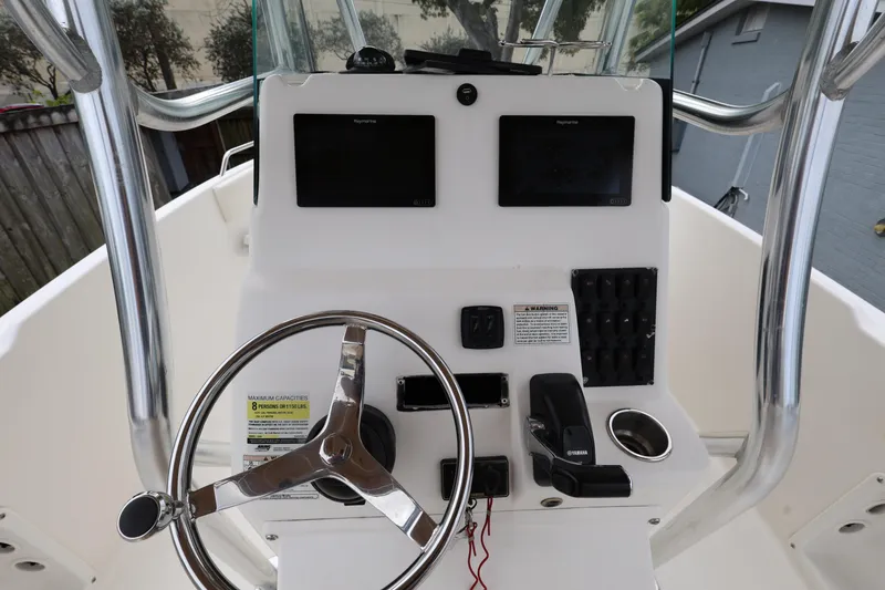Slide: The Image of Century 2200 Center Console 2018 boat dashboard with steering wheel and controls. - 13