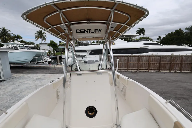 Slide: The Image of 2018 Century 2200 Center Console boat docked, featuring a spacious deck and T-top. - 18