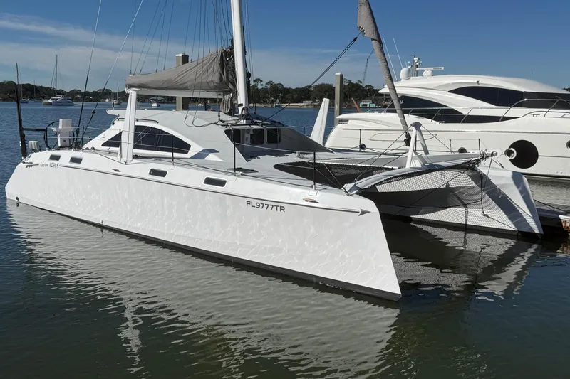 The Image of 2023 Schionning 1850 S catamaran docked in a marina, reflecting on calm water. - 0