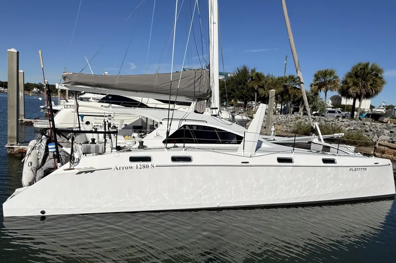Slide: The Image of 2023 Schionning 1850 S catamaran docked in a marina under clear blue skies. - 2