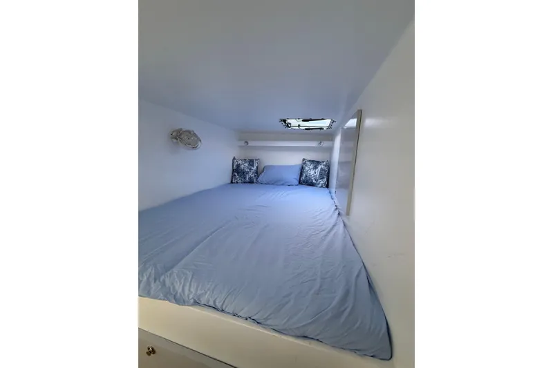 Slide: The Image of Cozy cabin interior of 2023 Schionning 1850 S with blue bedding and small window. - 20