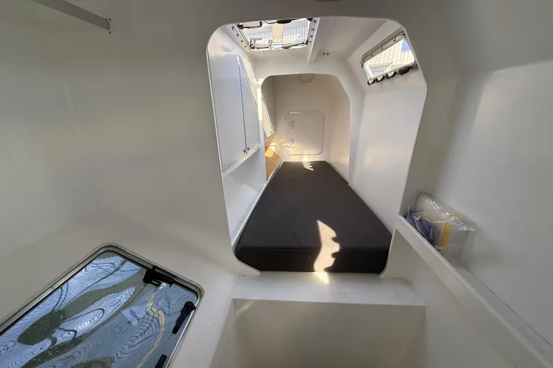 Slide: The Image of Interior of 2023 Schionning 1850 S catamaran, featuring a compact cabin with a bed. - 21