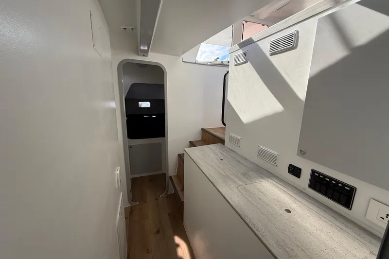 Slide: The Image of Interior of 2023 Schionning 1850 S catamaran, featuring modern design and wooden flooring. - 23