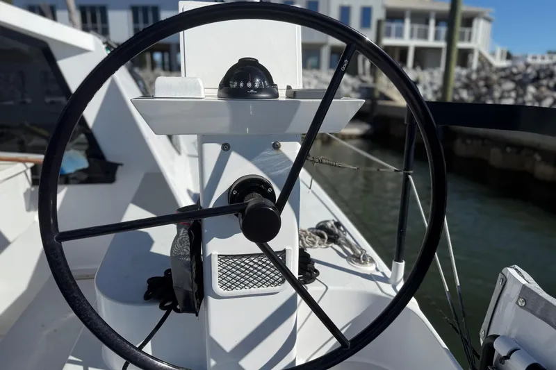 Slide: The Image of Steering wheel of 2023 Schionning 1850 S catamaran, docked at marina. - 4