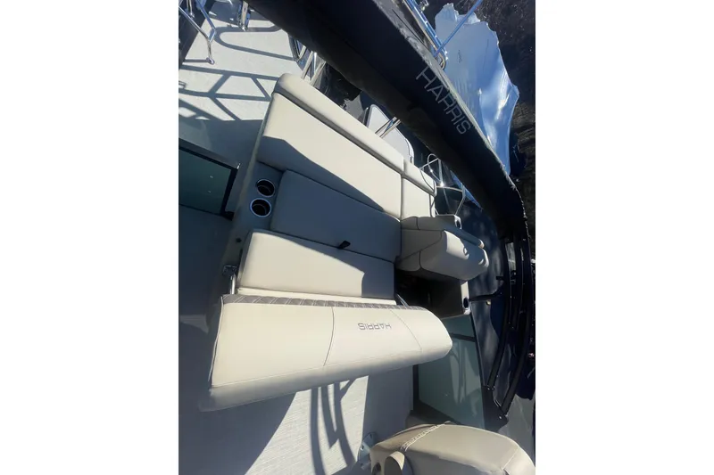 Slide: The Image of 2026 Harris Cruiser 210 boat interior with beige seating and cup holders. - 14