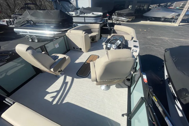 Slide: The Image of 2026 Harris Cruiser 210 pontoon boat interior with beige seating and steering console. - 16